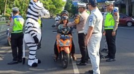 Kasat Lantas Polresta Pati, Kompol Asfauri memberikan helm anak berstandar SNI di kawasan Alun-alun Pati. Foto: Istimewa 