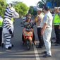 Kasat Lantas Polresta Pati, Kompol Asfauri memberikan helm anak berstandar SNI di kawasan Alun-alun Pati. Foto: Istimewa 