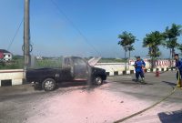 Petugas Damkar Pati menjinakkan api mobil terbakar di depan SPBU Bumirejo, Kecamatan Margorejo, Kabupaten Pati. Foto: Bang Horor