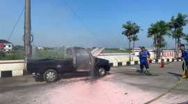 Petugas Damkar Pati menjinakkan api mobil terbakar di depan SPBU Bumirejo, Kecamatan Margorejo, Kabupaten Pati. Foto: Bang Horor