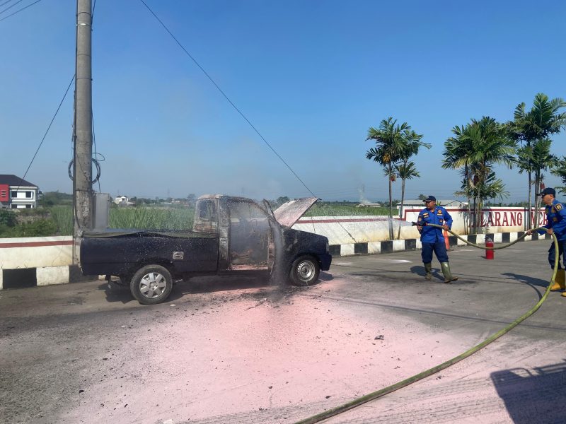 Petugas Damkar Pati menjinakkan api mobil terbakar di depan SPBU Bumirejo, Kecamatan Margorejo, Kabupaten Pati. Foto: Bang Horor